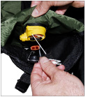 Access the inflator cap by turning the inflatable cell on the life preserver