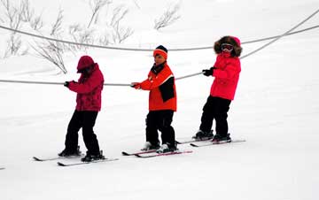 kids using tow rope while skiing